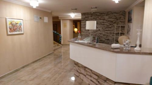 a kitchen with a counter and a stone wall at Hotel Admiral in Vinkovci