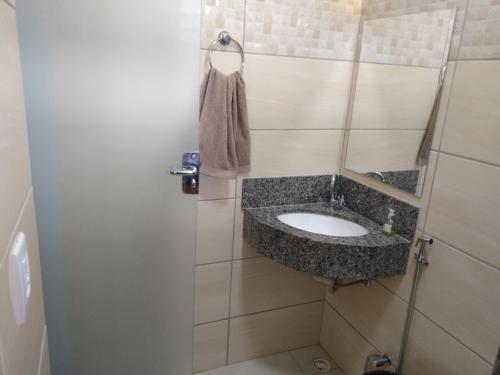 a small bathroom with a sink in a room at Sítio Pé da Serra - Pousada Rural in Capitólio