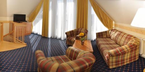 ein Hotelzimmer mit 2 Sofas und einem TV in der Unterkunft Chalet Sonnenhang Oberhof in Oberhof
