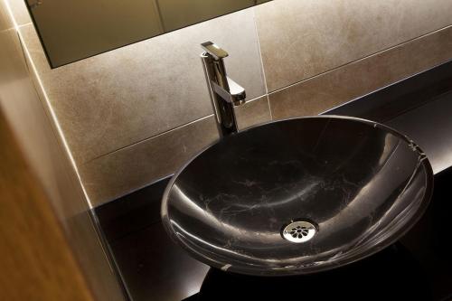 a black sink in a bathroom with a mirror at Ramada Plaza by Wyndham Prince George in Prince George