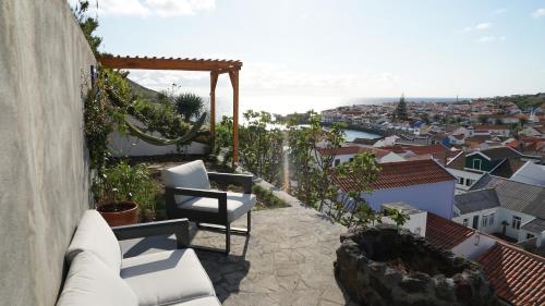 a balcony with white chairs and a view of a city at Casa Volta do Mar in Horta