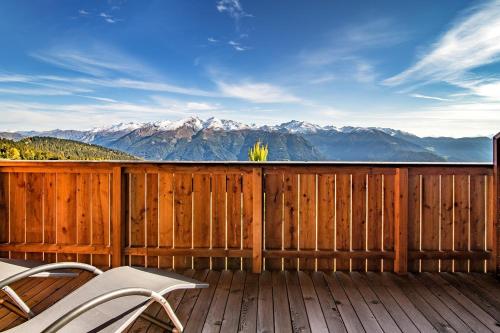 a deck with two chairs and a view of mountains at Chalet Stern in Vipiteno