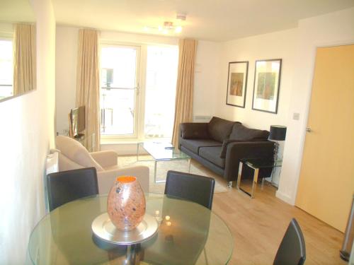 a living room with a glass table with a vase on it at New Central Woking 1 and 2 Bedroom Apartments with Free Gym, close to Train Station in Woking