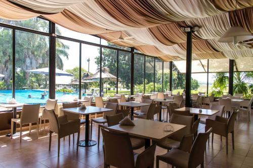 um restaurante com mesas e cadeiras e uma piscina em Campo & Golf em Victoria