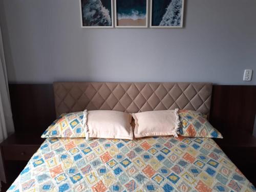 a bed with a quilt and two pillows on it at Loft super charmoso no centro de Nova Friburgo in Nova Friburgo