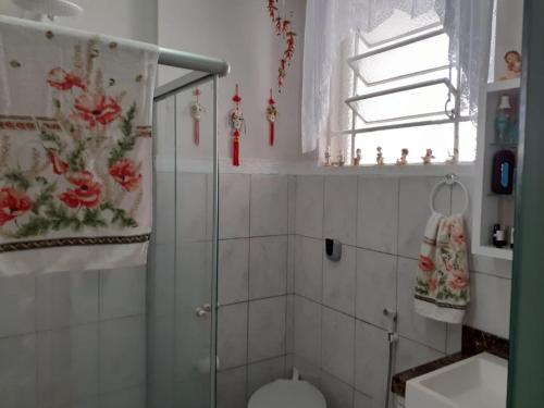 a bathroom with a shower and a toilet and a window at Loft super charmoso no centro de Nova Friburgo in Nova Friburgo