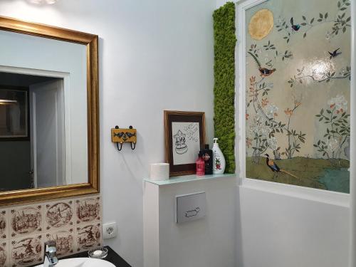 a bathroom with a mirror and a picture and a sink at Elisabeth Apartment in Oradea