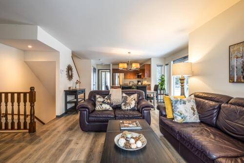 a living room with a couch and a table at Aiglon by Rendez-Vous Mont-Tremblant in Mont-Tremblant