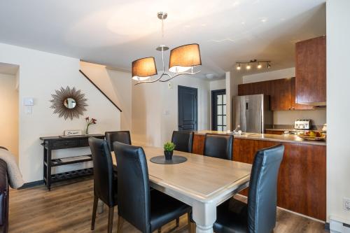 a dining room and kitchen with a table and chairs at Aiglon by Rendez-Vous Mont-Tremblant in Mont-Tremblant