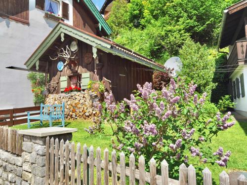 a wooden fence in front of a house with flowers at Pension Karner in Mittenwald