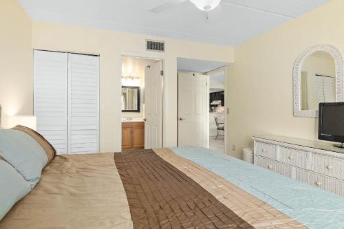 a bedroom with a bed and a television in it at Unit 2105 - Ocean & Racquet Resort in Saint Augustine Beach