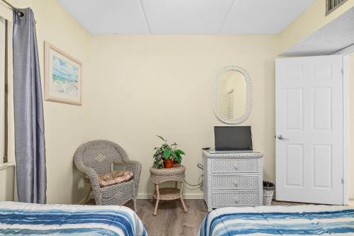 a bedroom with two beds and a tv and a mirror at Unit 2105 - Ocean & Racquet Resort in Saint Augustine Beach