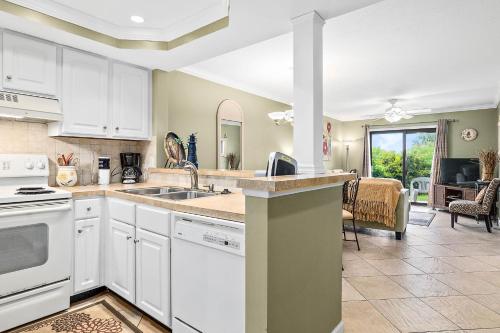 a kitchen with white appliances and a dining room at Unit 3127 - Ocean & Racquet Club in Saint Augustine Beach