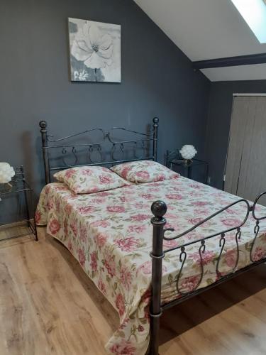 a bedroom with a bed with a floral bedspread at Gite Vallée et Semoy in Tournavaux