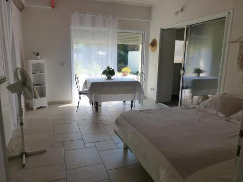 Schlafzimmer mit einem Bett, einem Tisch und einem Fenster in der Unterkunft L'EPICERIE in Pau