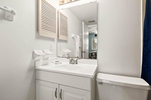 a white bathroom with a sink and a mirror at Unit 6302 - Ocean & Racquet Resort in Saint Augustine Beach