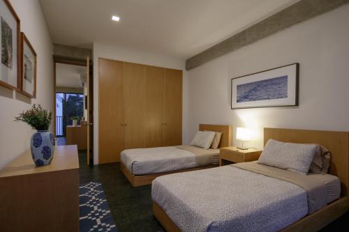 Habitación de hotel con 2 camas y pasillo en Apartamentos Buenos Aires en Guadalajara