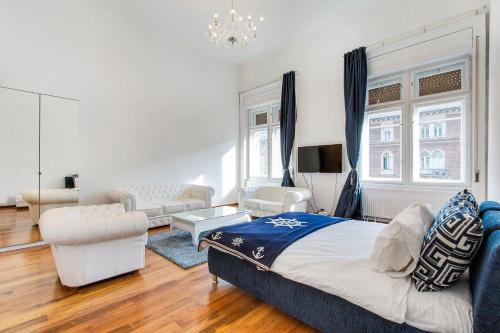 a bedroom with a king sized bed and a living room at Royale Apartment in Budapest