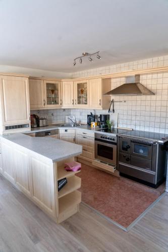 a kitchen with wooden cabinets and a stove top oven at Ferienwohnung im Idyll 1 in Hengersberg