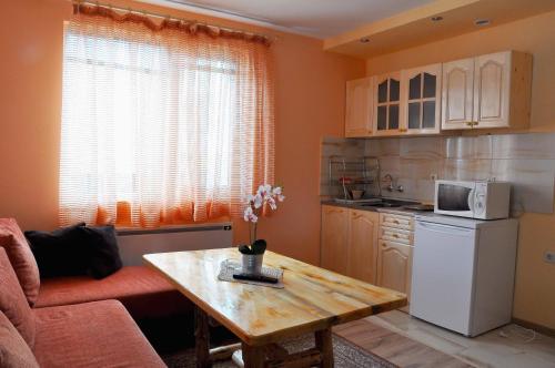 a kitchen with a table and a white refrigerator at Guest House Eli in Sapareva Banya