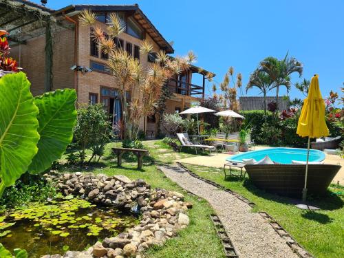 un patio trasero con piscina y una casa con piscina en EccO Capricornio, en Caraguatatuba