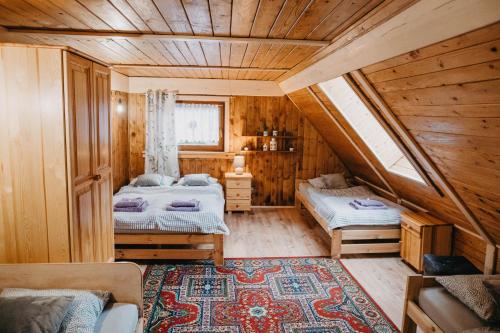 a bedroom with two beds in a wooden house at Domek Sienna 1a Czarna Góra in Stronie Śląskie
