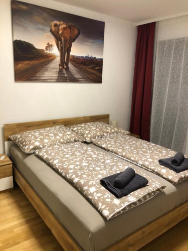 a bed in a room with a picture of an elephant at Neubau Wohnung Stadlau in Vienna