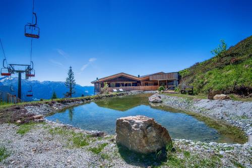 a house on a hill with a rock in a pond at Chalet Stern in Vipiteno