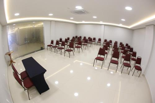 a conference room with chairs and a table and a podium at Hotel Caiuá Express Umuarama in Umuarama