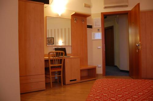 um quarto com uma secretária, um espelho e um quarto em Hotel Belie em San Martino di Lupari