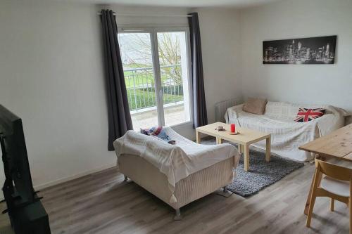 a living room with a couch and a table at Appartement contemporain rénové à neuf avec cuisine équipé - Val de reuil in Val de Reuil