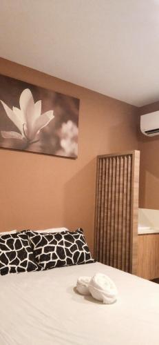 a bedroom with a bed with a flower painting on the wall at Tai Hoe Hotel in Singapore