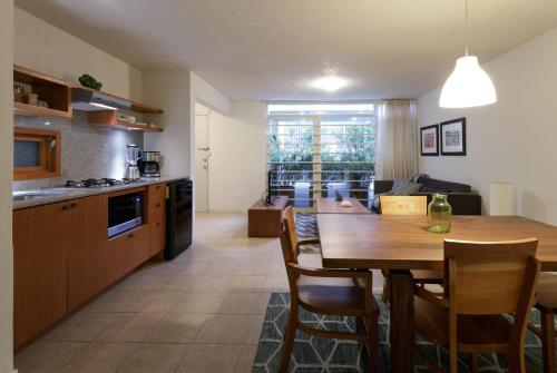 a kitchen and living room with a wooden table and chairs at Apartamentos West End in Guadalajara