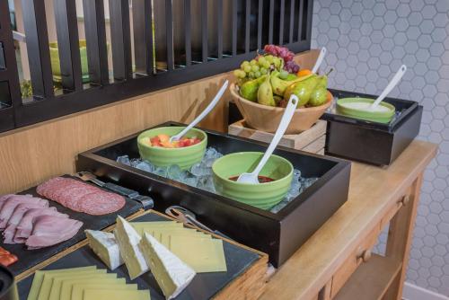 a buffet with bowls of food and a bowl of fruit at Holiday Inn Manchester West by IHG in Manchester