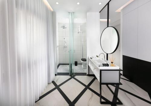 a bathroom with a sink and a shower and a mirror at King George suites in Jerusalem