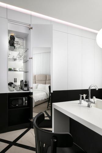 a bathroom with a sink and a chair and a bedroom at King George suites in Jerusalem