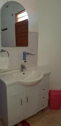 y baño con lavabo blanco y espejo. en Northern Pearl, en Gulu