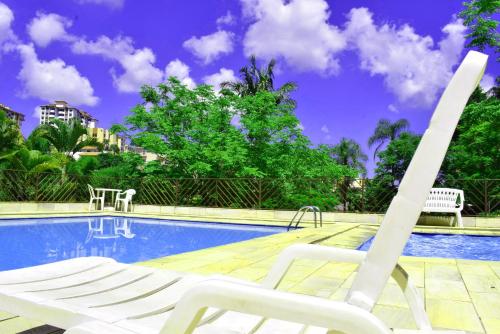 a pair of chairs sitting next to a swimming pool at Hotel Moinho de Pedra in Serra Negra