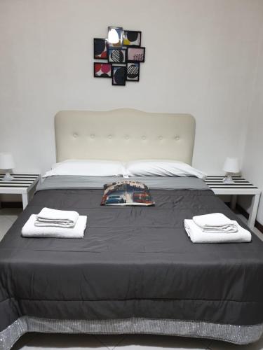 a bedroom with a bed with two towels on it at Alba central City in Palermo