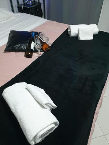a bed with white towels on a black blanket at Alba central City in Palermo