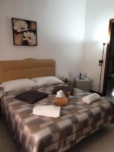 a large bed with two pillows and a basket on it at Alba central City in Palermo