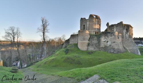 an old castle on top of a grassy hill at La maison de Conches in Conches-en-Ouche