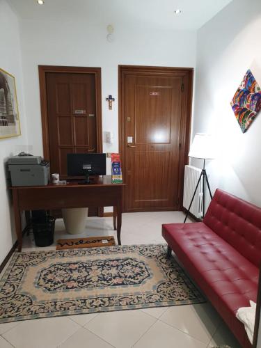 a living room with a red couch and a desk at Alba central City in Palermo