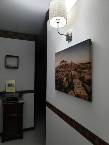 a picture hanging on a wall with a light at Alba central City in Palermo