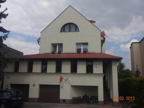 biały budynek z czerwonym dachem i oknem w obiekcie Centro Unita w Krakowie