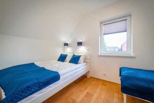 Amber Resort في ريفال: غرفة نوم بسرير وملاءات زرقاء ونافذة
