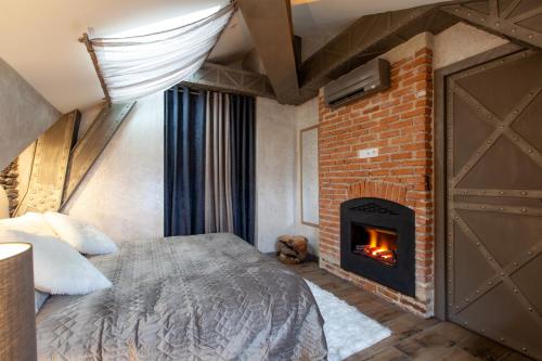 a bedroom with a bed and a brick fireplace at OLuxuxy49 - Appartements T3 de prestige, Place du Ralliement, 2ème 3ème et 4ème étage SANS ASCENSEUR in Angers