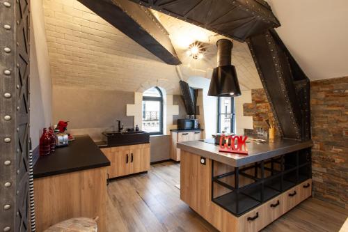 a large kitchen with wooden floors and a brick wall at OLuxuxy49 - Appartements T3 de prestige, Place du Ralliement, 2ème 3ème et 4ème étage SANS ASCENSEUR in Angers