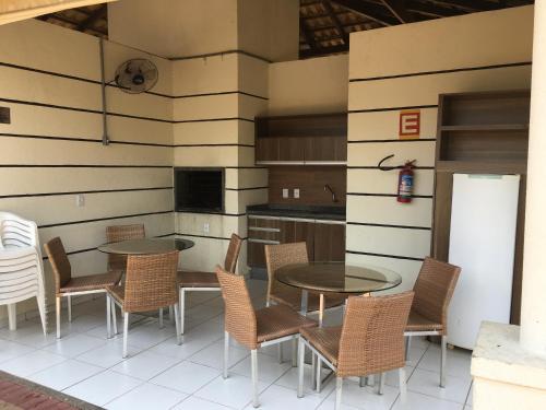 a patio with two tables and chairs and a kitchen at Apartamento Rocha Cuiabá in Cuiabá