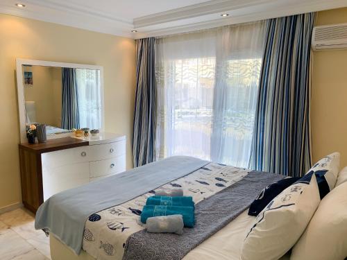 een slaapkamer met een bed, een dressoir en een spiegel bij Comfort & Relax Home "Marine Holiday" in Mahmutlar